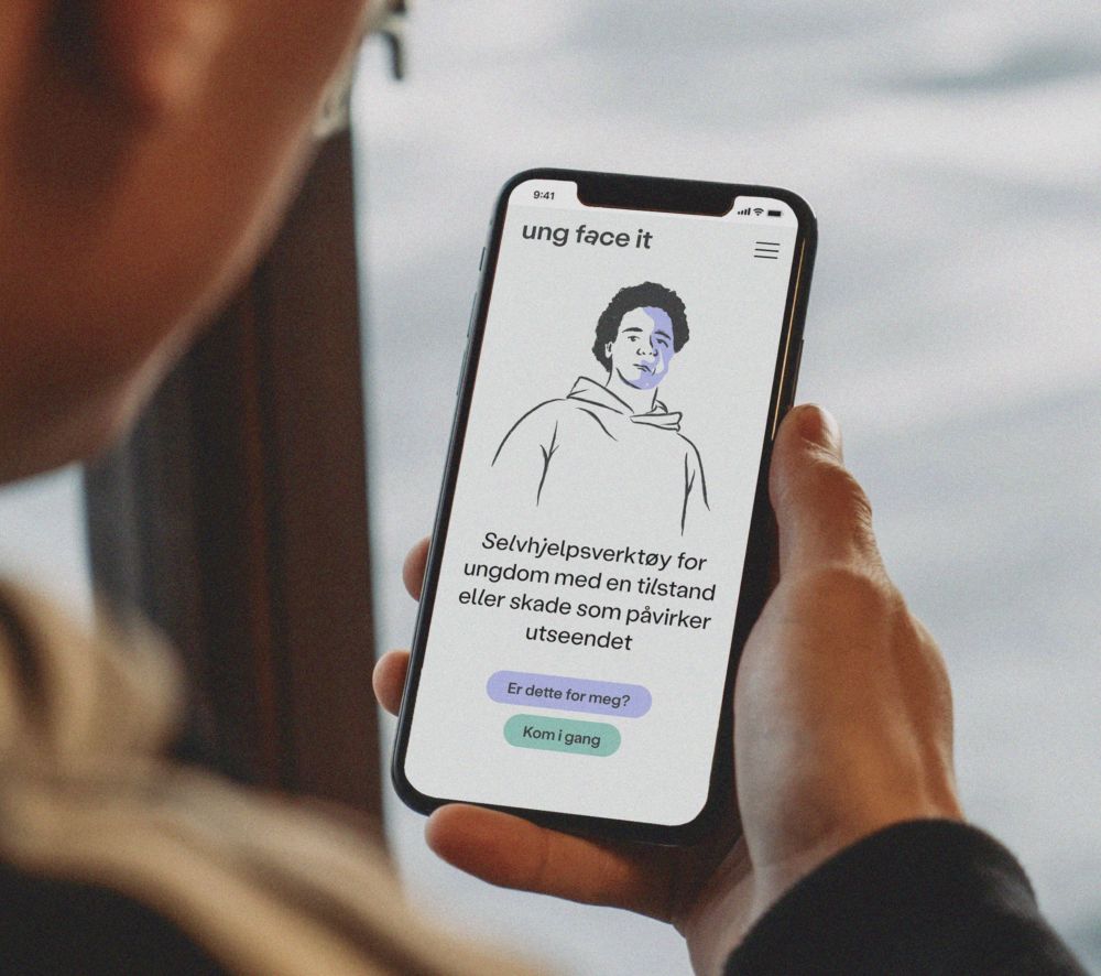 Ung face it illustrasjonsbilde som viser en hånd som holder en mobil med skjermbilde fra nettsiden